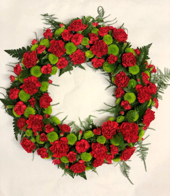 <h2>Extra Large Classic Wreath in Red and Green | Funeral Flowers</h2>
<ul>
<li>Approximate Size W 50cm H 50cm (extra large)</li>
<li>Hand created red and green wreath in fresh flowers</li>
<li>To give you the best we may occasionally need to make substitutes</li>
<li>Funeral Flowers will be delivered at least 2 hours before the funeral</li>
<li>For delivery area coverage see below</li>
</ul>
<br>
<h2>Liverpool Flower Delivery</h2>
<p>We have a wide selection of Funeral Wreaths offered for Liverpool Flower Delivery. Funeral Wreaths can be provided for you in Liverpool, Merseyside and we can organize Funeral flower deliveries for you nationwide. Funeral Flowers can be delivered to the Funeral directors or a house address. They can not be delivered to the crematorium or the church.</p>
<br>
<h2>Flower Delivery Coverage</h2>
<p>Our shop delivers funeral flowers to the following Liverpool postcodes L1 L2 L3 L4 L5 L6 L7 L8 L11 L12 L13 L14 L15 L16 L17 L18 L19 L24 L25 L26 L27 L36 L70 If your order is for an area outside of these we can organise delivery for you through our network of florists. We will ask them to make as close as possible to the image but because of the difference in stock and sundry items it may not be exact.</p>
<br>
<h2>Liverpool Funeral Flowers | Wreaths</h2>
<p>This striking wreath-shaped design has been loving handcrafted by our florists and features a classic selection of flowers including carnations and spray chrysanthemums in red and greens are nestled into this traditional circular extra large wreath.</p>
<br>
<p>A funeral wreath is flowers arranged in a circular shape with a hole in the centre. This circular shape symbolises the circle of life or eternal life. They are suitable for sending directly to a funeral whether you are family or a friend.</p>
<br>
<p>Contents of 16 inch oasis ring: 20 Red Carnations, 14 Red Spray Carnations, 7 Green Spray Chrysanthemums and mixed Foliage.</p>
<br>
<h2>Best Florist in Liverpool</h2>
<p>Trust Award-winning Liverpool Florist, Booker Flowers and Gifts, to deliver funeral flowers fitting for the occasion delivered in Liverpool, Merseyside and beyond. Our funeral flowers are handcrafted by our team of professional fully qualified who not only lovingly hand make our designs but hand-deliver them, ensuring all our customers are delighted with their flowers. Booker Flowers and Gifts your local Liverpool Flower shop.</p>
<br>
<p><em>Jane Catherine and Family - Review by Post - Funeral Florist Liverpool</em></p>
<br>
<p><em>Thank you so much for the amazing flowers you arranged for our mum she would have loved them. Love Jane, Catherine and family</em></p>
<br>